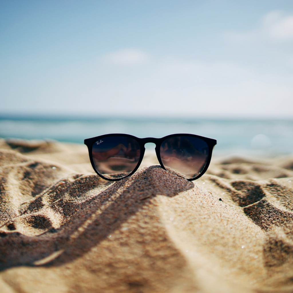 lunettes de soleil seule posée dans le sable face à la mer preuve d'une check-list réussie