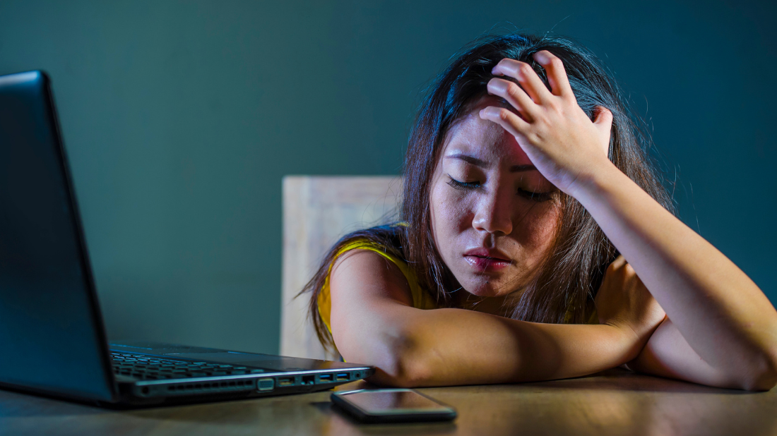 femme devant son ordinateur ayant un mal de tête