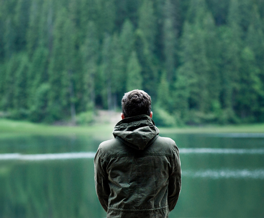 homme devant un lac appreciant le silence de la nature