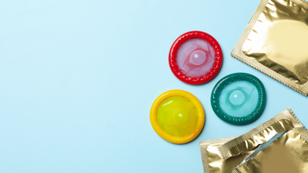 Préservatifs de couleurs sur un fond bleu et 2 préservatifs dans leur emballage doré