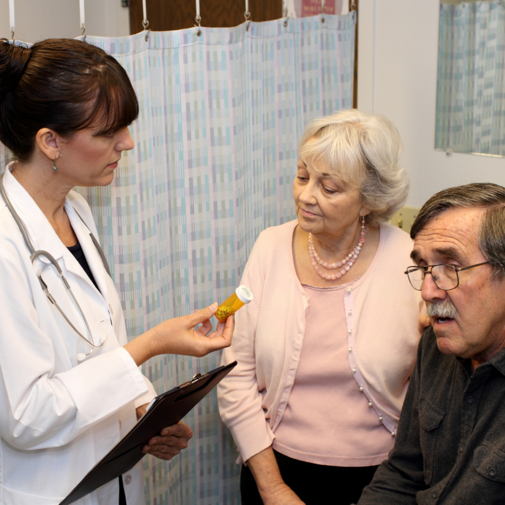 Intervenant professionnel de santé parlant à un couple de personnes âgées et de leur dose de médicaments