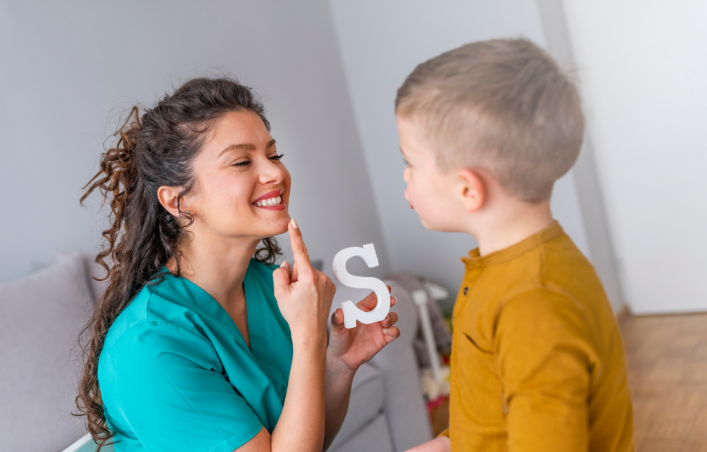 Orthophoniste réalisant un signe à un jeune garçon et illustrant la surdité et la déficience auditive