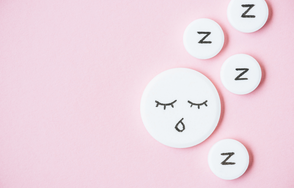 vue sur des somnifères contre le sommeil avec visage dessiné et signes Z sur un fond rose