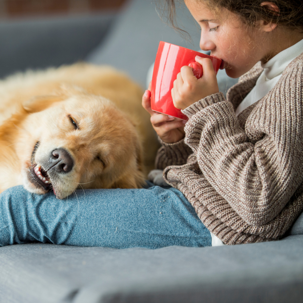 Bienfait n°1 - jeune fille buvant une tasse de chocolat sur son canapé avec son chien