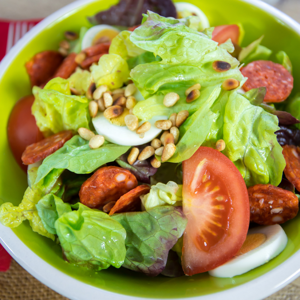 salade composée avec des tomates, de la salade verte, du chorizo et des pignons de pin idéale pour la rentrée