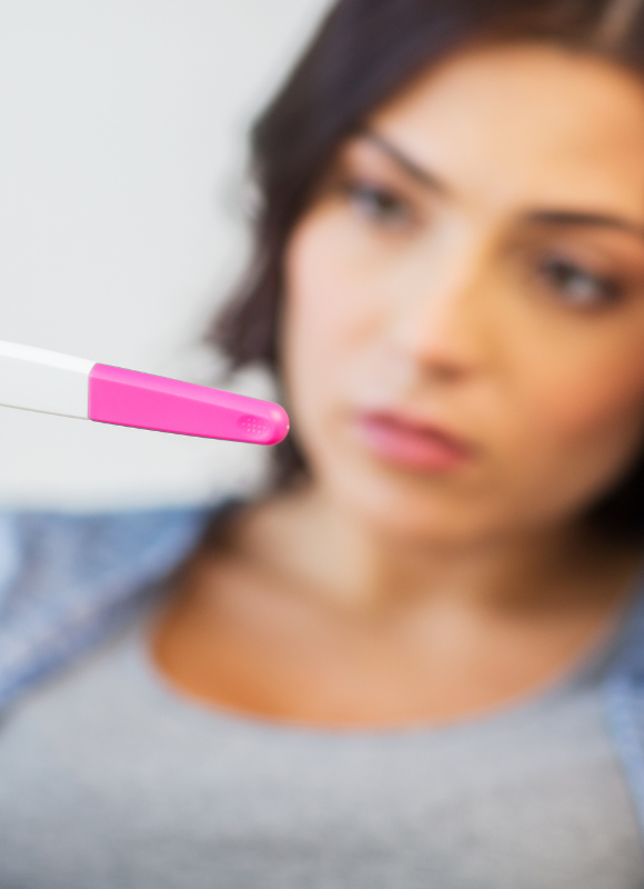 femme regardant fixement son test de grossesse