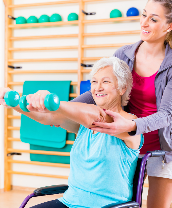 Enseignante en activité physique adaptée aidant une personne âgée à porter des poids en extension