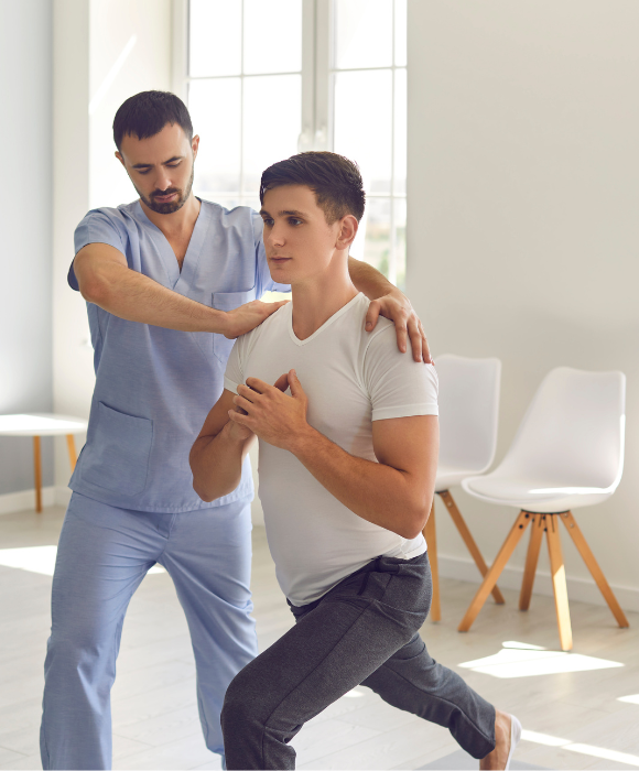 Masseur-kinésithérapeute aidant à la posture d'un jeune homme
