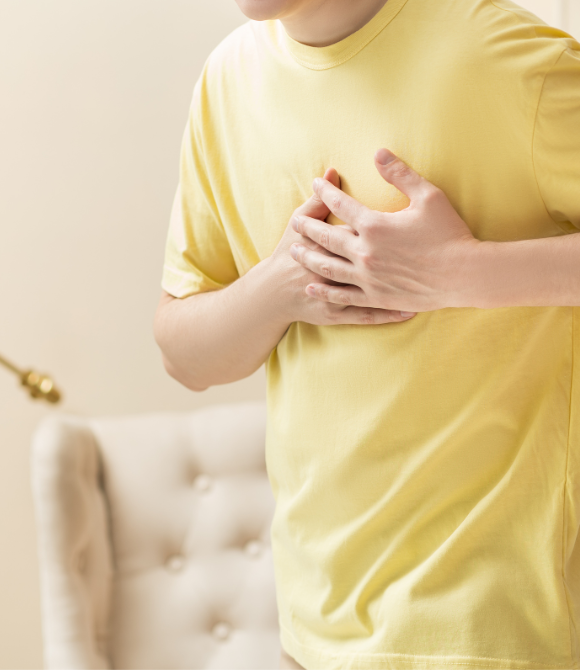 homme en tee-shirt jaune avec ses mains sur le torse souffrant de problème vasculaire