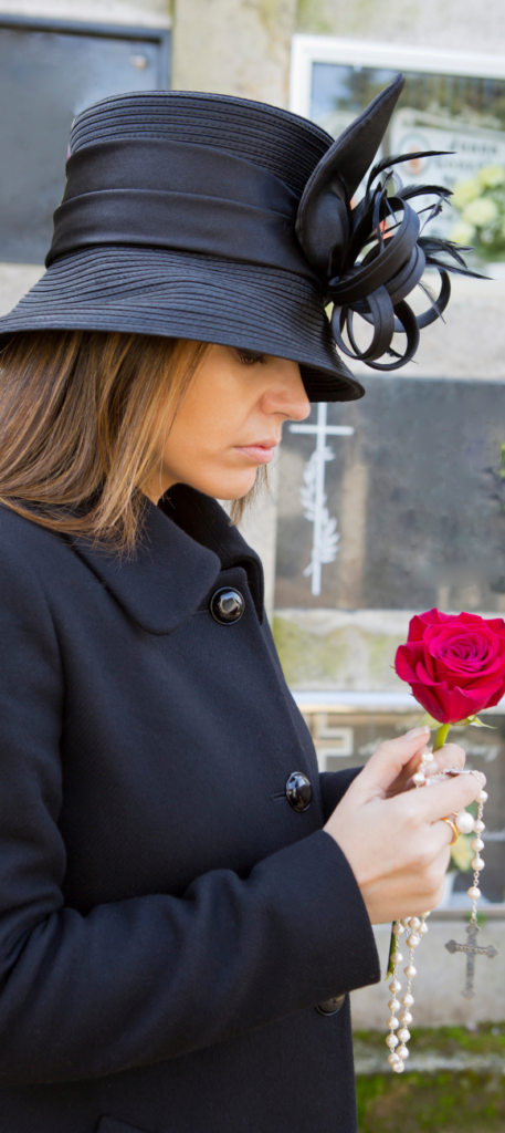 jeune femme en deuil toute vêtue de noir tenant fermement une rose et une collier 