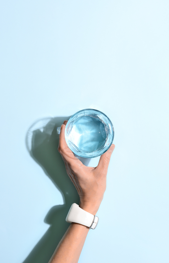 verre d'eau sur fond bleu permettant une bonne hydratation