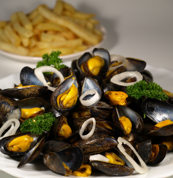 moules de bouchot servies avec des oignons et du persil