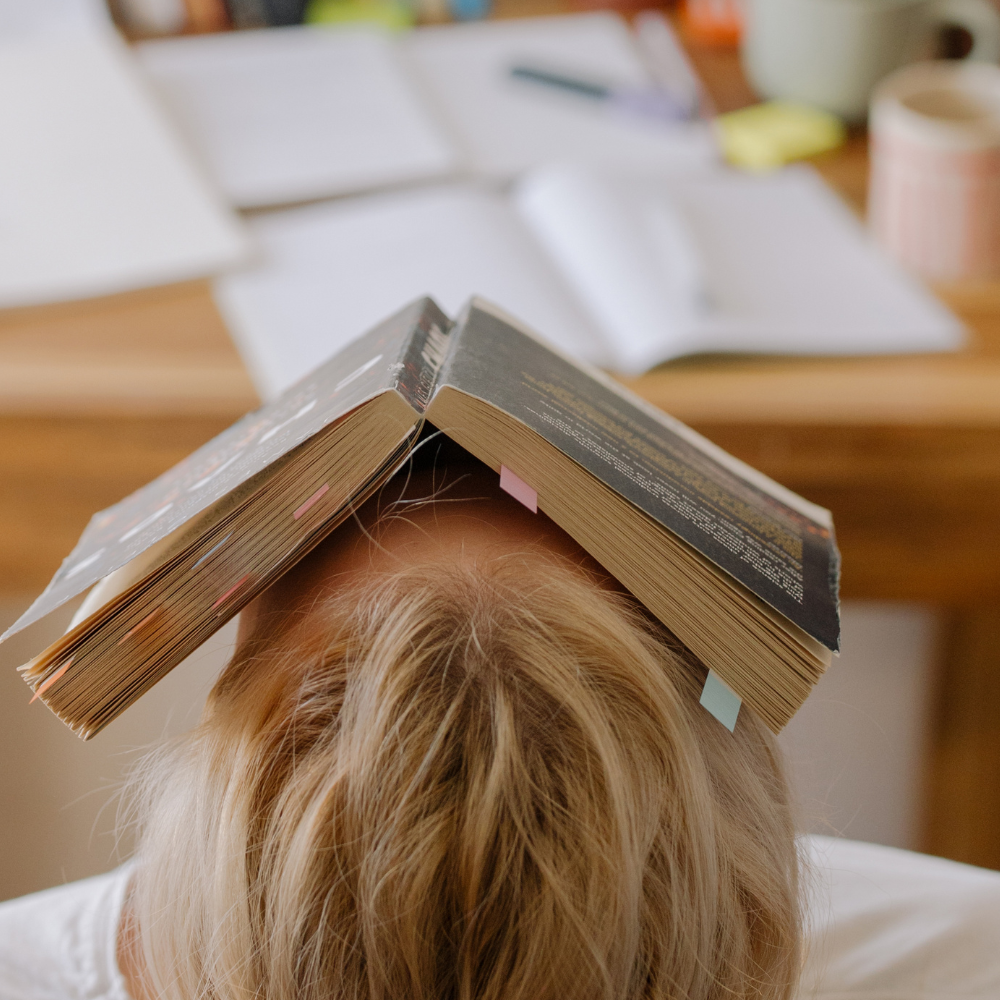 Homme dans son canapé piquant du nez avec un livre ouvert sur la tête symbolisant un défi pour arrêter de fumer