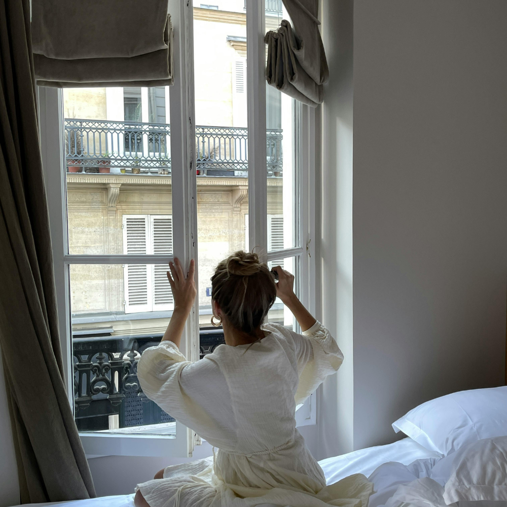 la fenêtre de son appartement en fin de journée pour rafraichir son logement