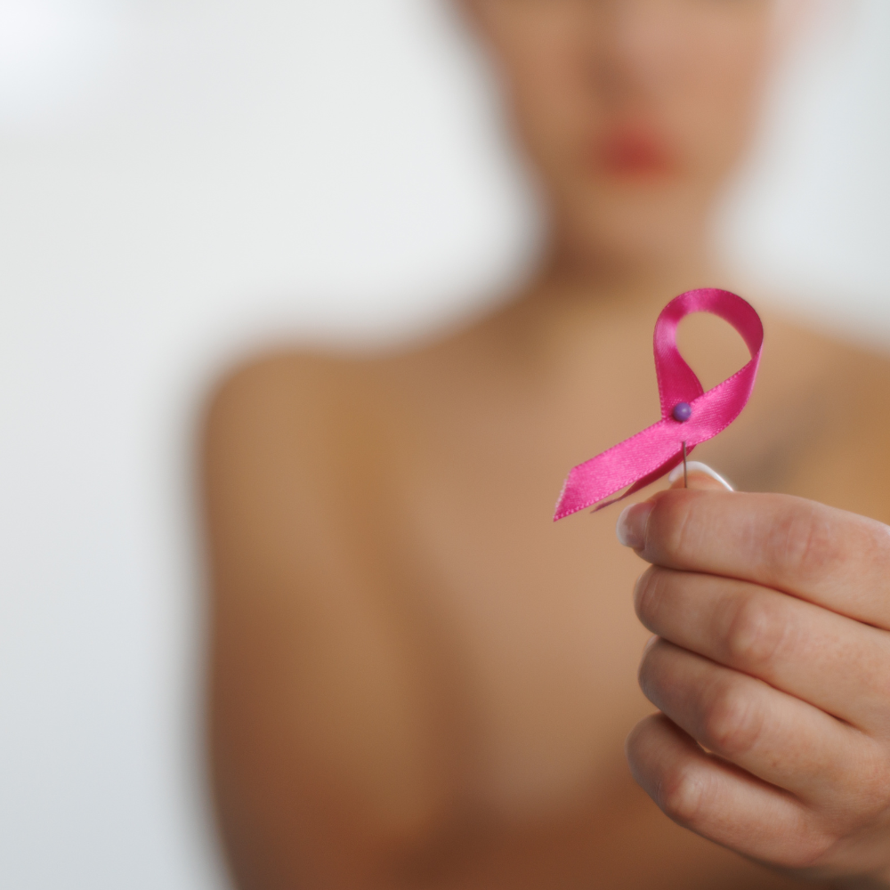 Femme flouen arrière plan tenant un ruban rose
