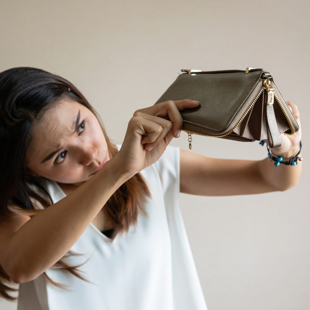 Jeune femme qui retourne son porte-monnaie qui est désespérément vide car elle n'a pas bénéficier du tiers payant mutlor