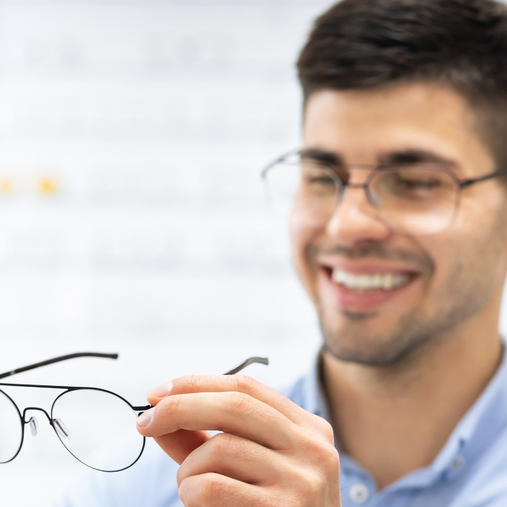 Opticien qui tend une paire de lunettes à son client